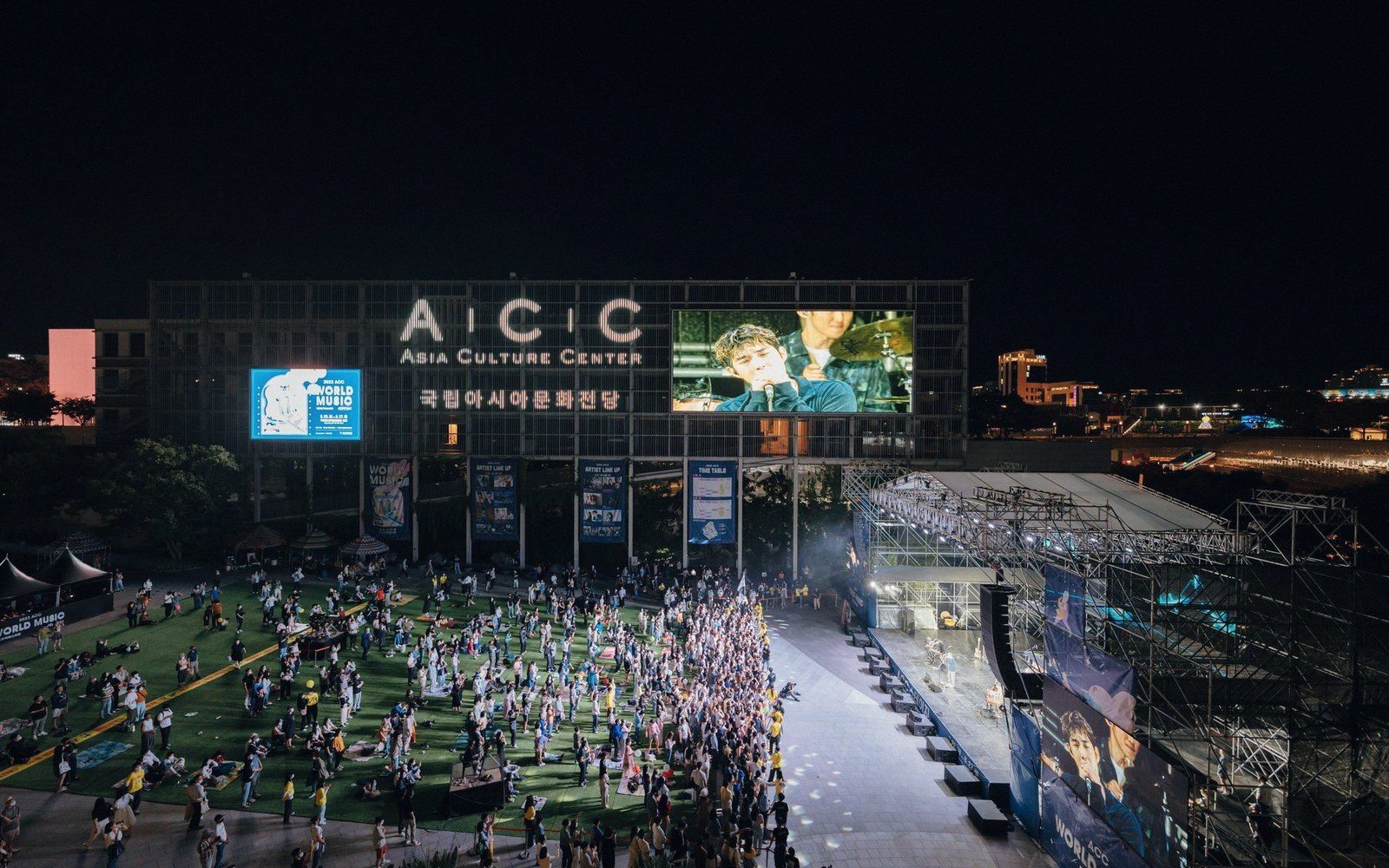 Crowds gather at night for an outdoor concert beneath the Asia Culture Center's illuminated screen